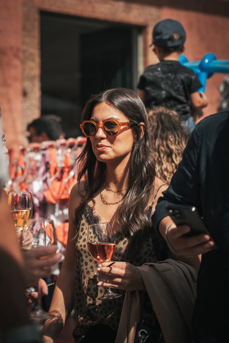 Cliente a usar óculos de sol com copo de vinho Casa de Sezim, no Mercado em Sezim, Guimarães.