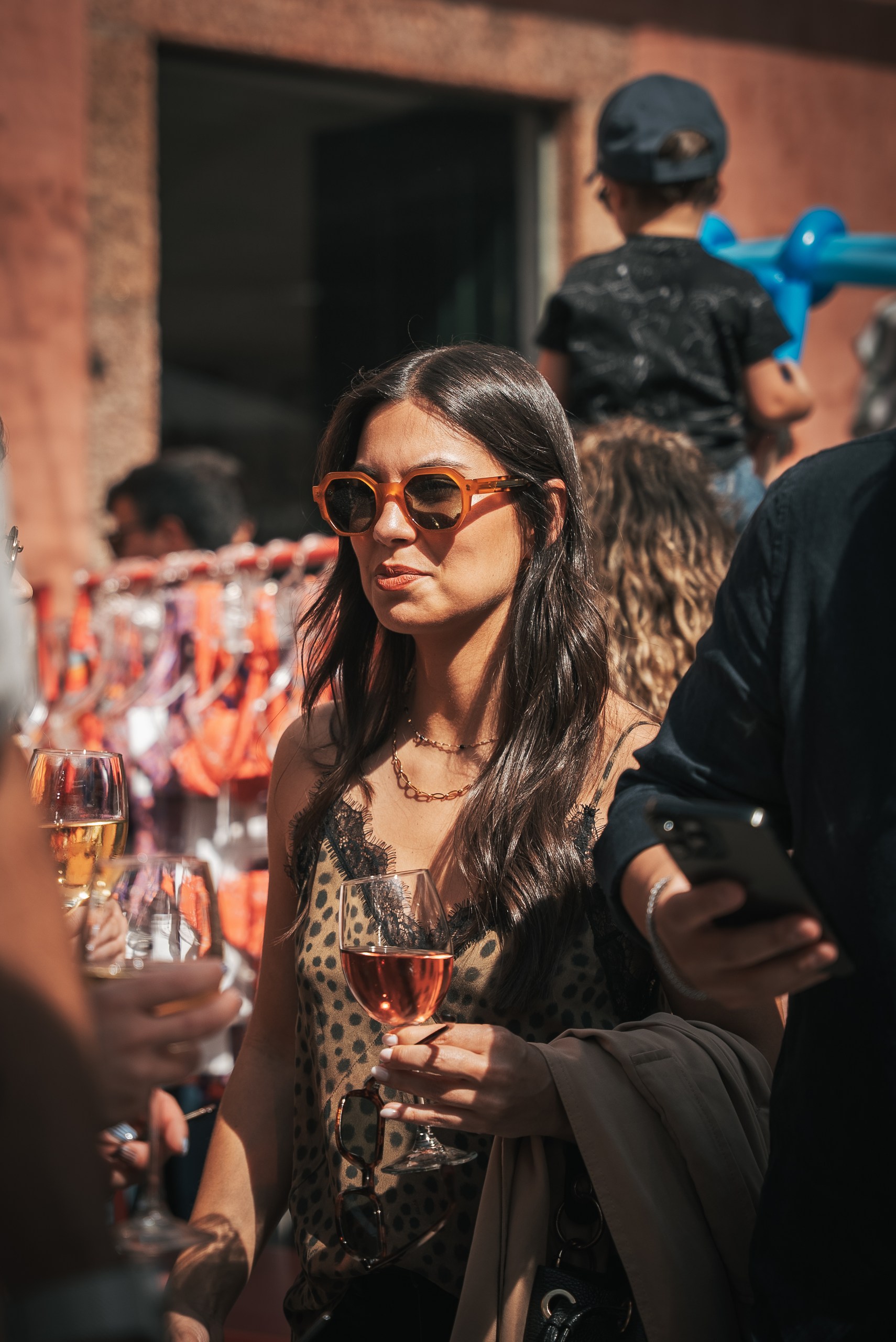 Cliente a usar óculos de sol com copo de vinho Casa de Sezim, no Mercado em Sezim, Guimarães.