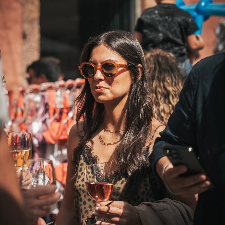 Cliente a usar óculos de sol com copo de vinho Casa de Sezim, no Mercado em Sezim, Guimarães.